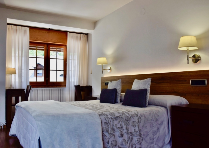 Habitació equipada amb llit doble, tres butaques i una taula